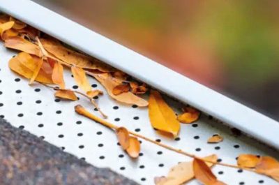 clogs Leaves clogging the edge of a residential roof highlight the need for Gutter Installation in Redmond to prevent water damage and ensure proper drainage.