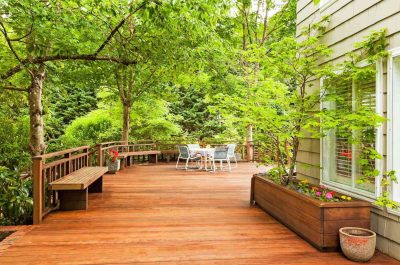 enhance Freshly cleaned wooden deck surrounded by greenery after professional deck and fence cleaning in Kirkland.