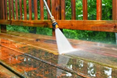 power-washing-wooden-deck-1 High-pressure water blasting away dirt from a dirty surface, showcasing the power and effectiveness of Pressure Washing Services Redmond.