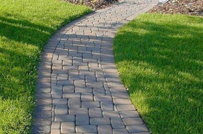 pressure Walkway freshly cleaned by Pressure Washing Services in Redmond, with lush green grass along the edges, revealing a bright, like-new surface.